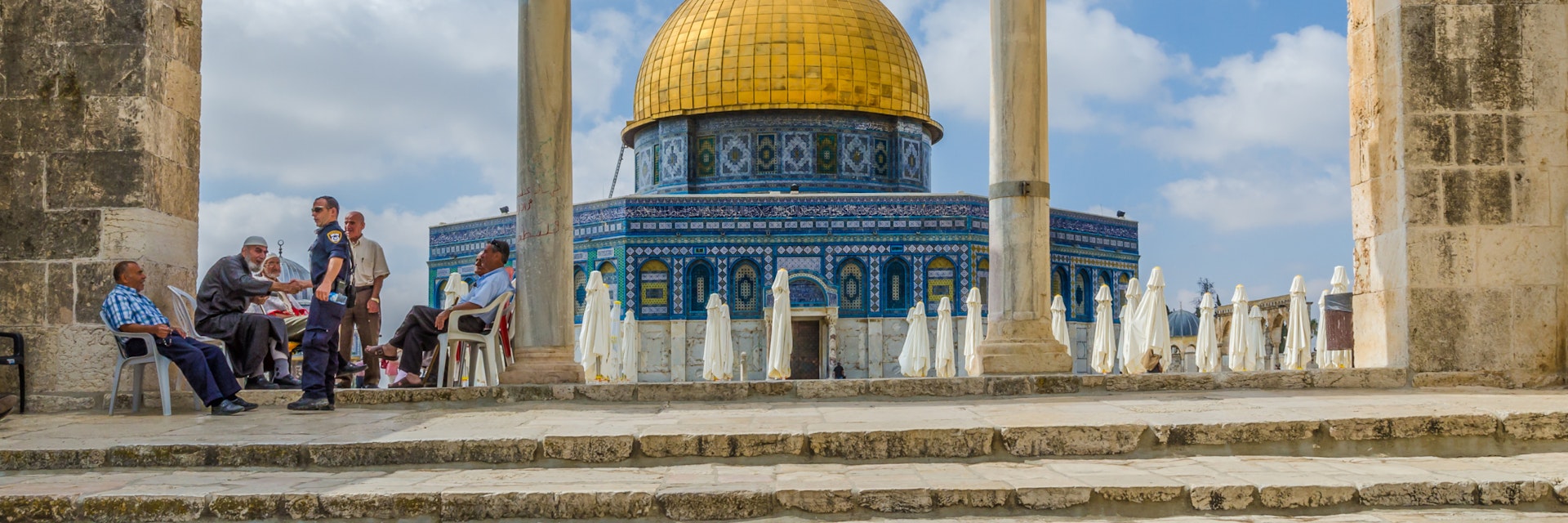 JERUSALEM, ISRAEL JUNE 10 2015: Israeli Temple Mount policeman greets the locals under the arches near the Dome of the Rock on the Temple Mount on June 10 2015 in the Old City of Jerusalem Israel.; Shutterstock ID 408810679; Your name (First / Last): Lauren Keith; GL account no.: 65050; Netsuite department name: Online Editorial; Full Product or Project name including edition: Middle East Online Highlights Update