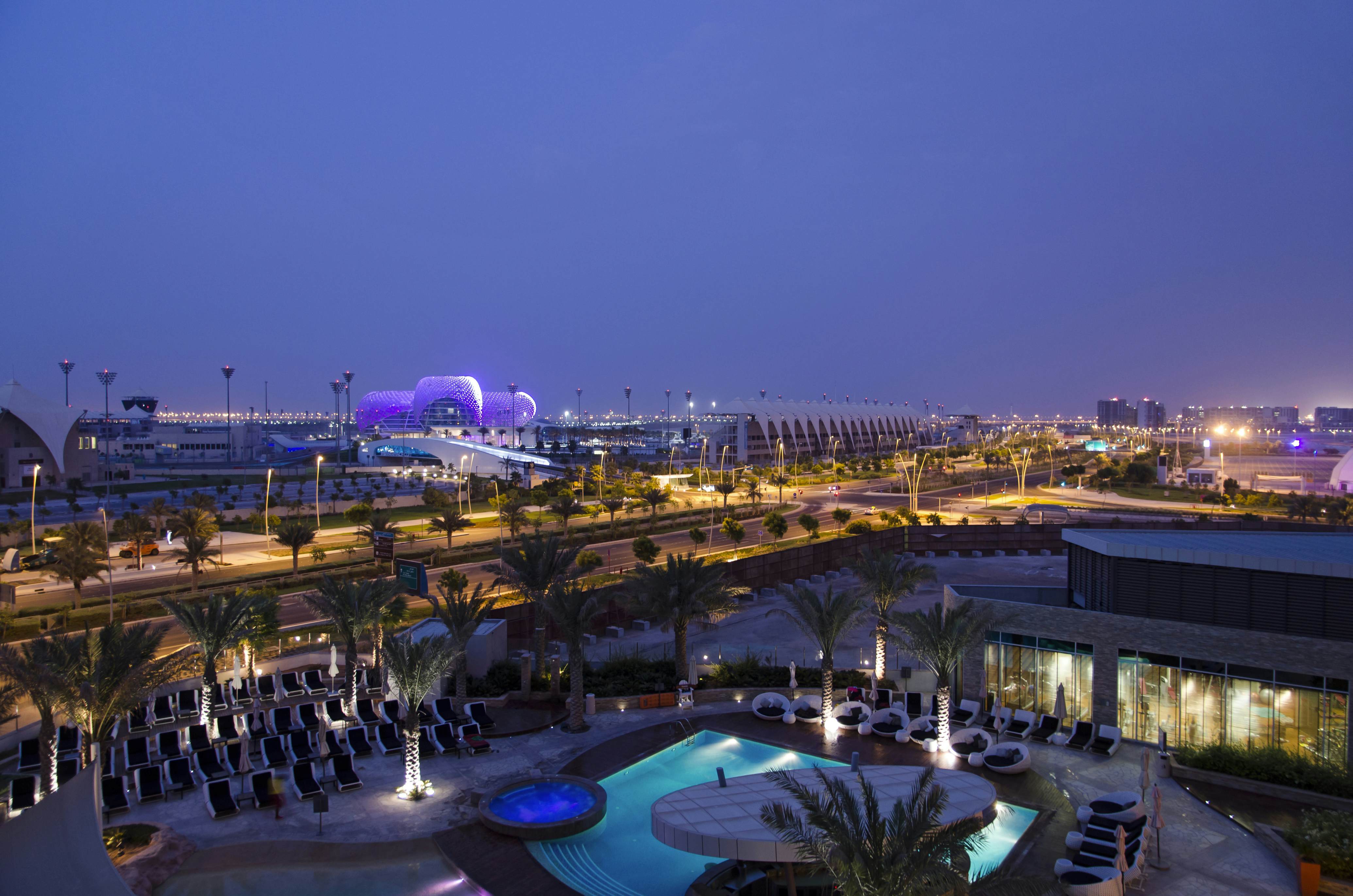 View over modern hotel pool to the Yas island Hotel and formula 1 circuit