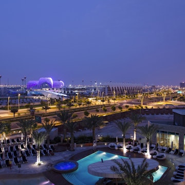 View over modern hotel pool to the Yas island Hotel and formula 1 circuit