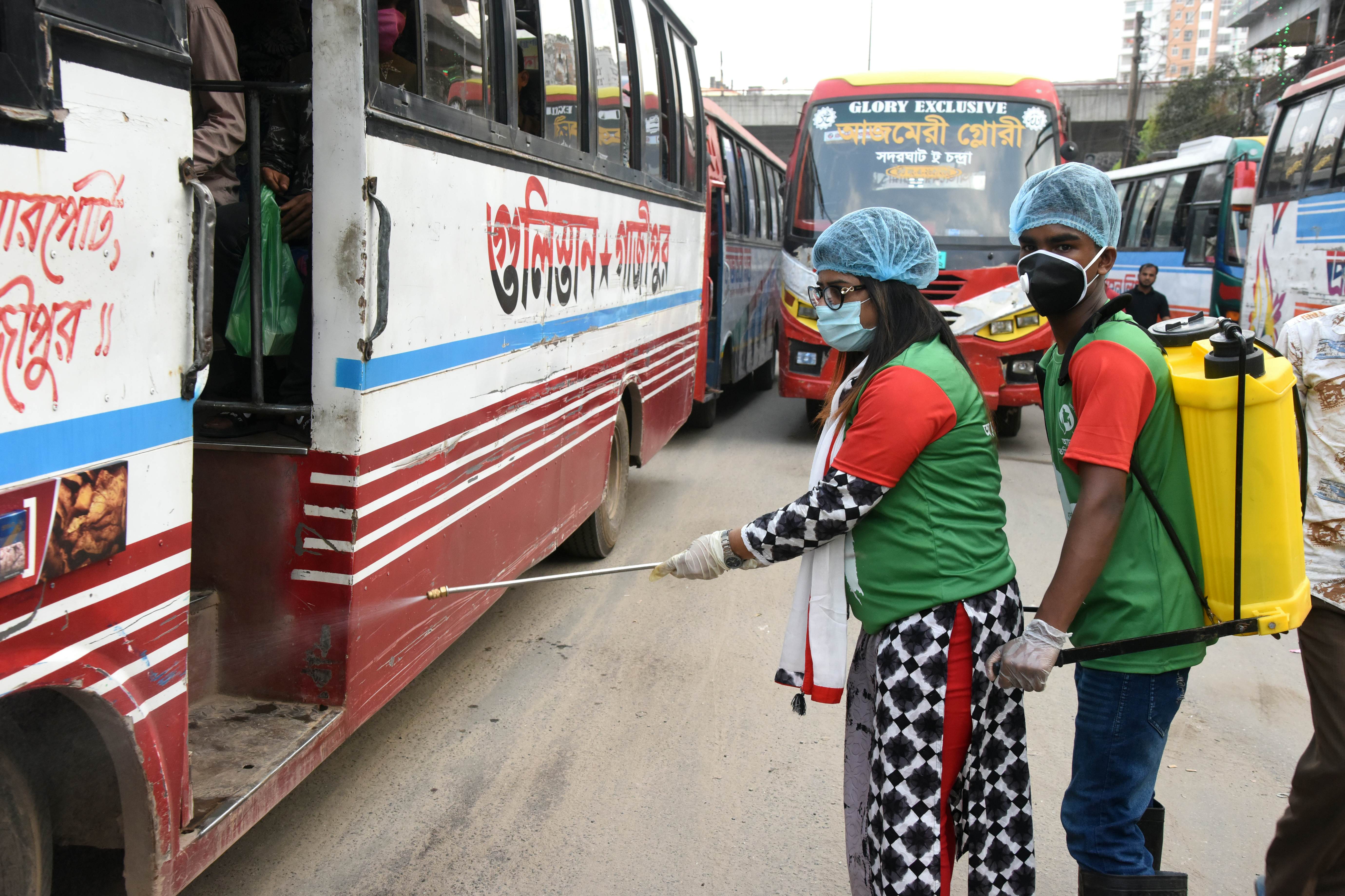 Bangladeshi volunteer sprays disinfectant inside a bus
