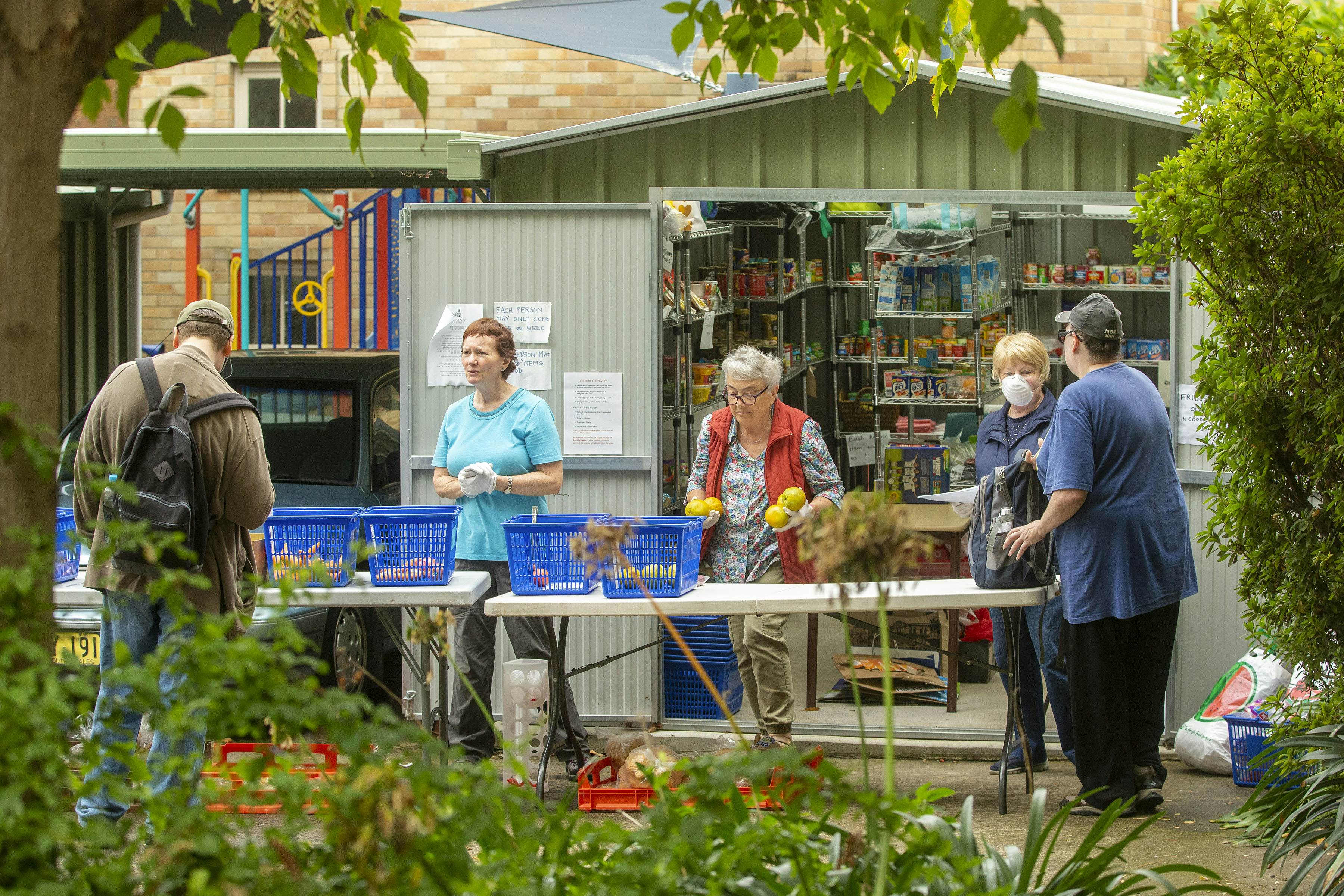 Volunteers Kerin Brown, Felicity Baker and Margaret Baseley serve people at St Paul's Anglican Church in Burwood on March 24, 2020 in Sydney, Australia