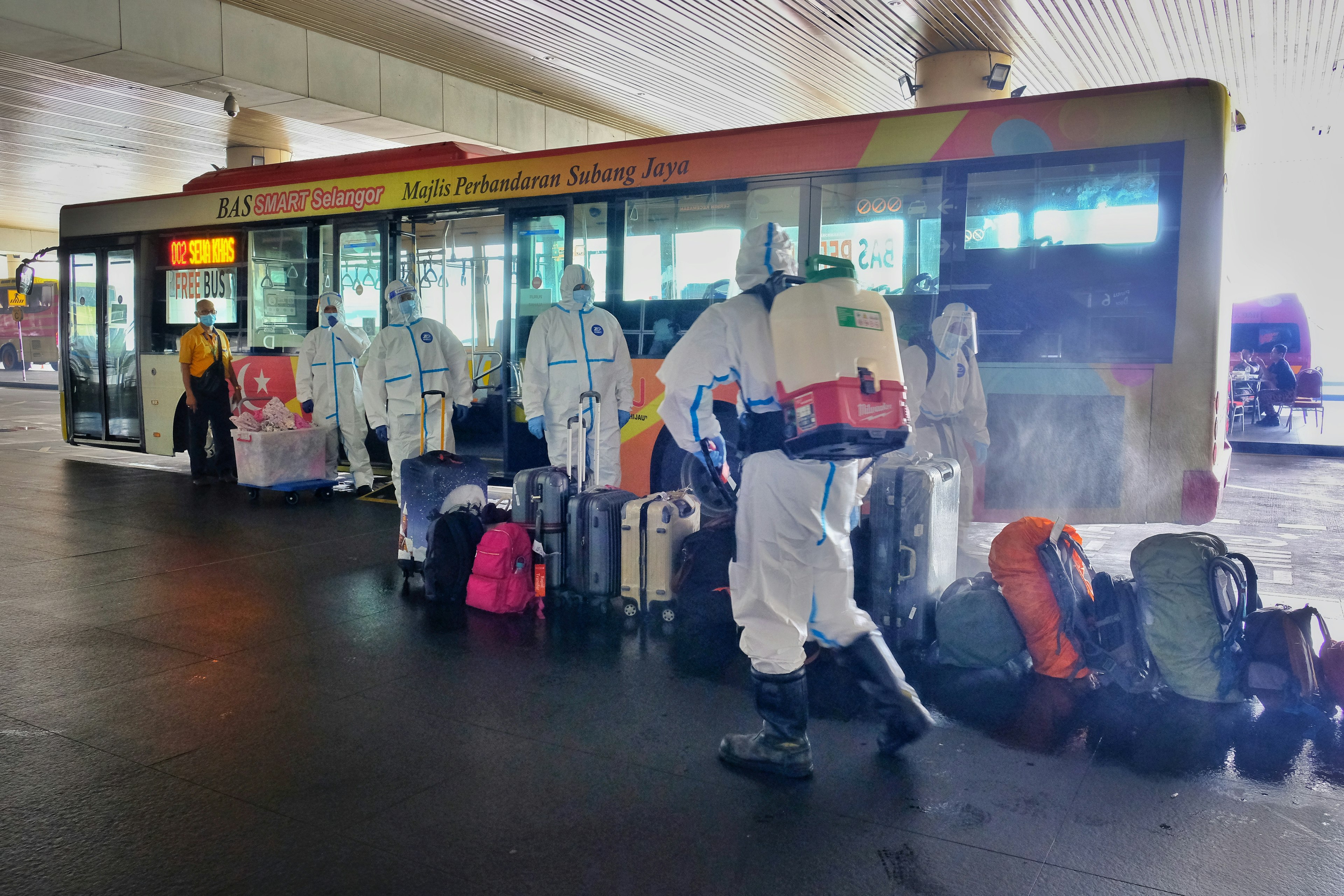 Bags and luggage are sanitised by bus station workers