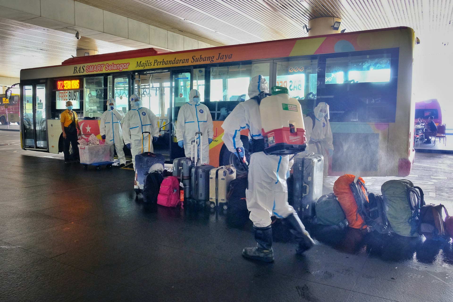 Bags and luggage are sanitised by bus station workers