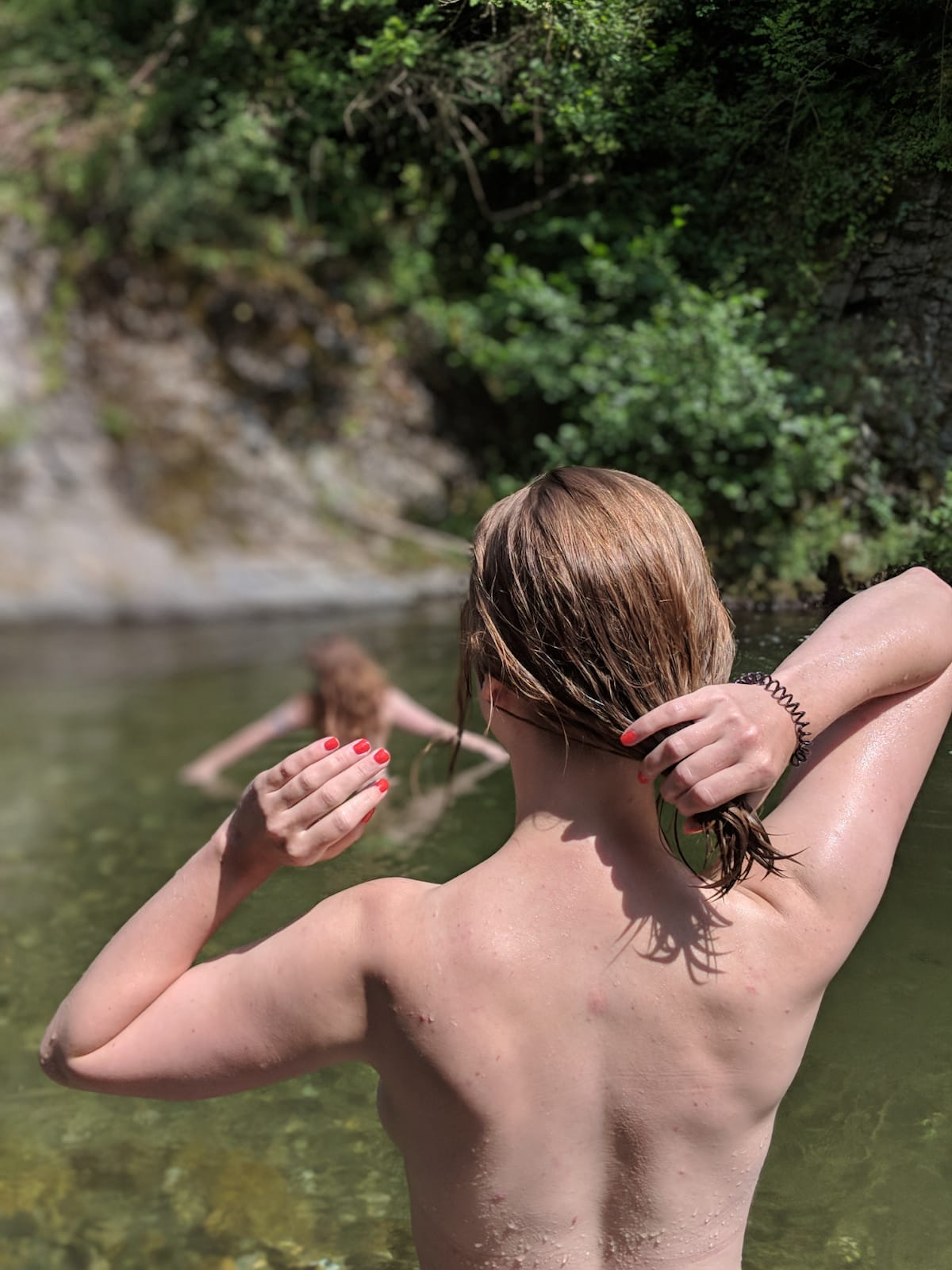 Two women wade in a lake