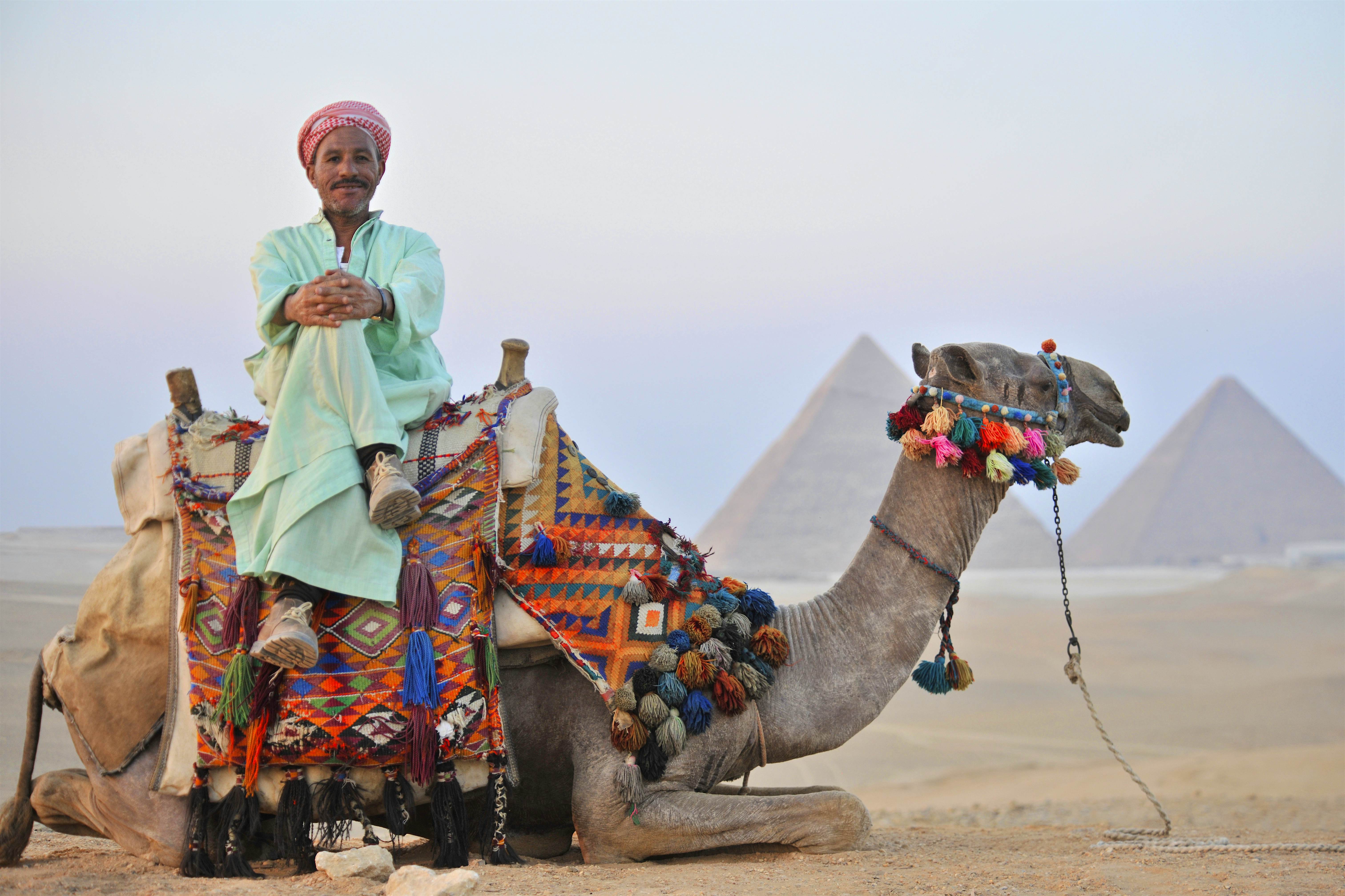 Egyptian man sitting on camel near pyramids of Giza