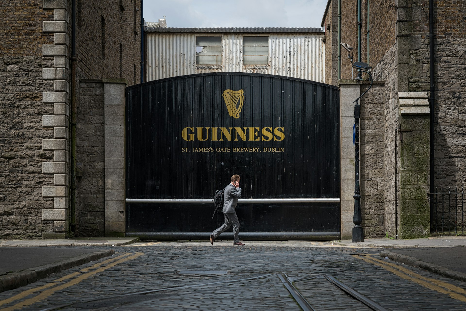 A man walks past the iconic gates to the Guinness brewery in Dublin