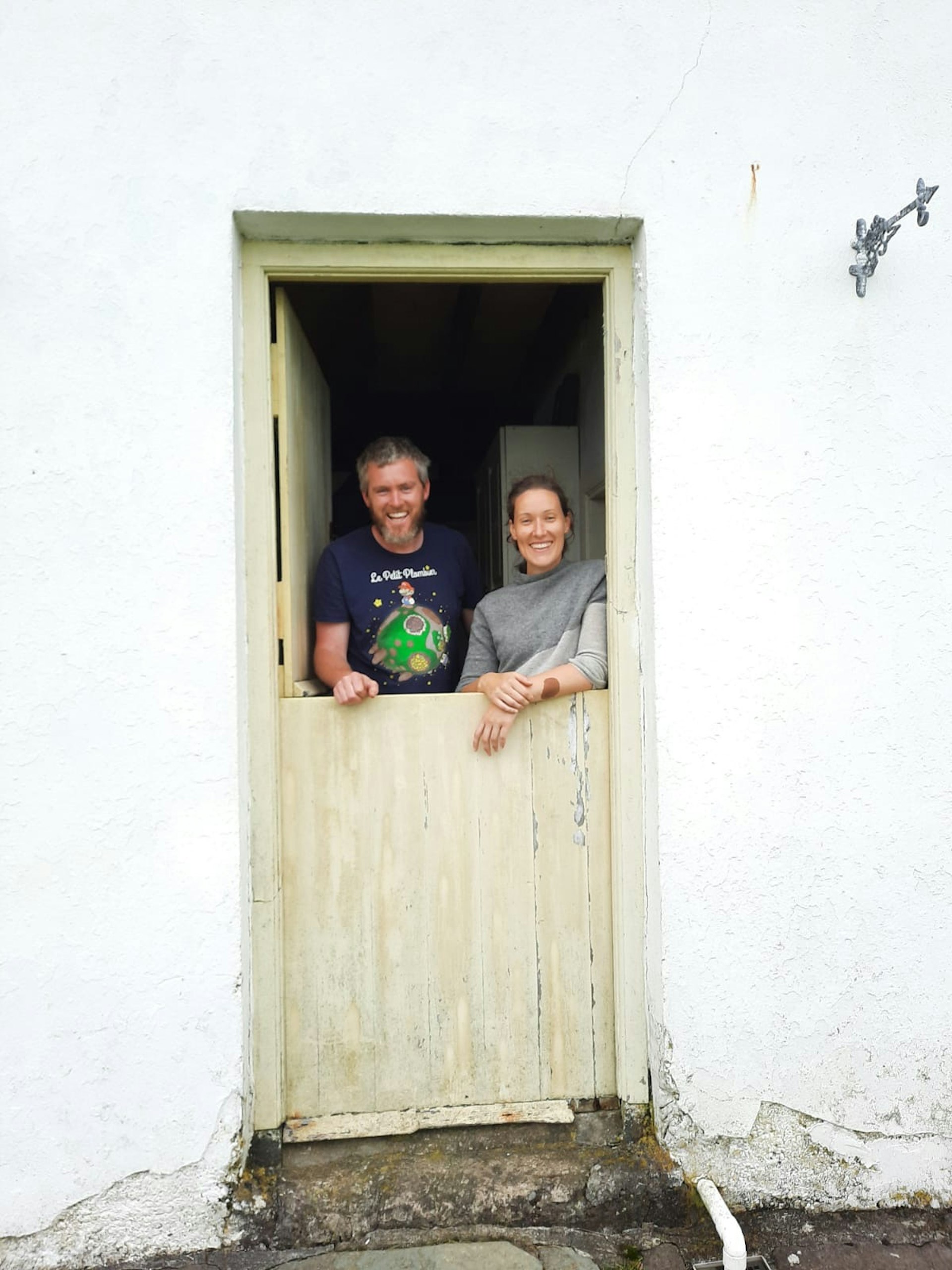 Couple Eoin Boyle and Annie Birney look out from the door of their cottage