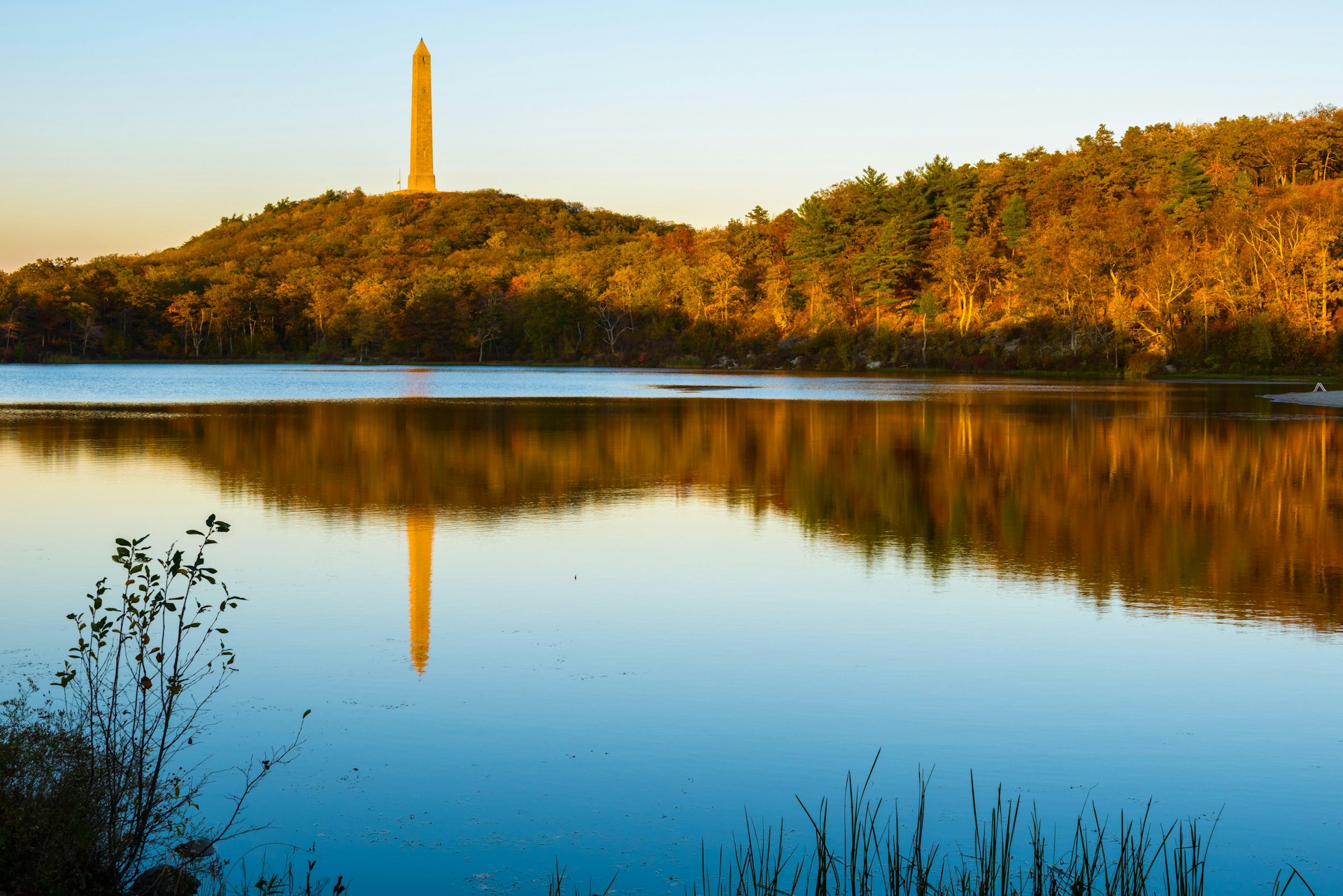 A 1930s war monument is reflected in the lake on a fall evening at High Point State Park in New Jersey