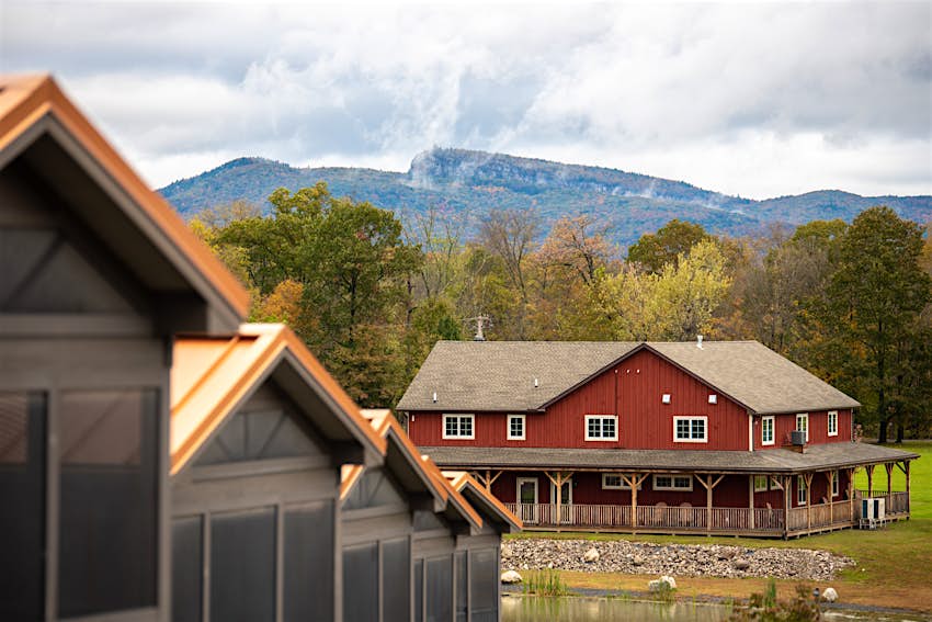 A red cabin with a mountain range in the background