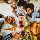 High angle view of happy African American family toasting during Thanksgiving lunch at dining table.