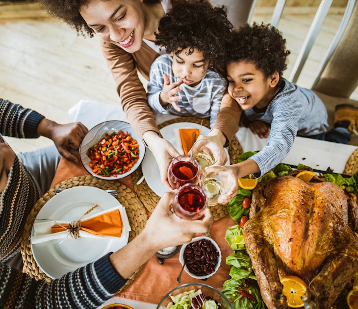 High angle view of happy African American family toasting during Thanksgiving lunch at dining table.