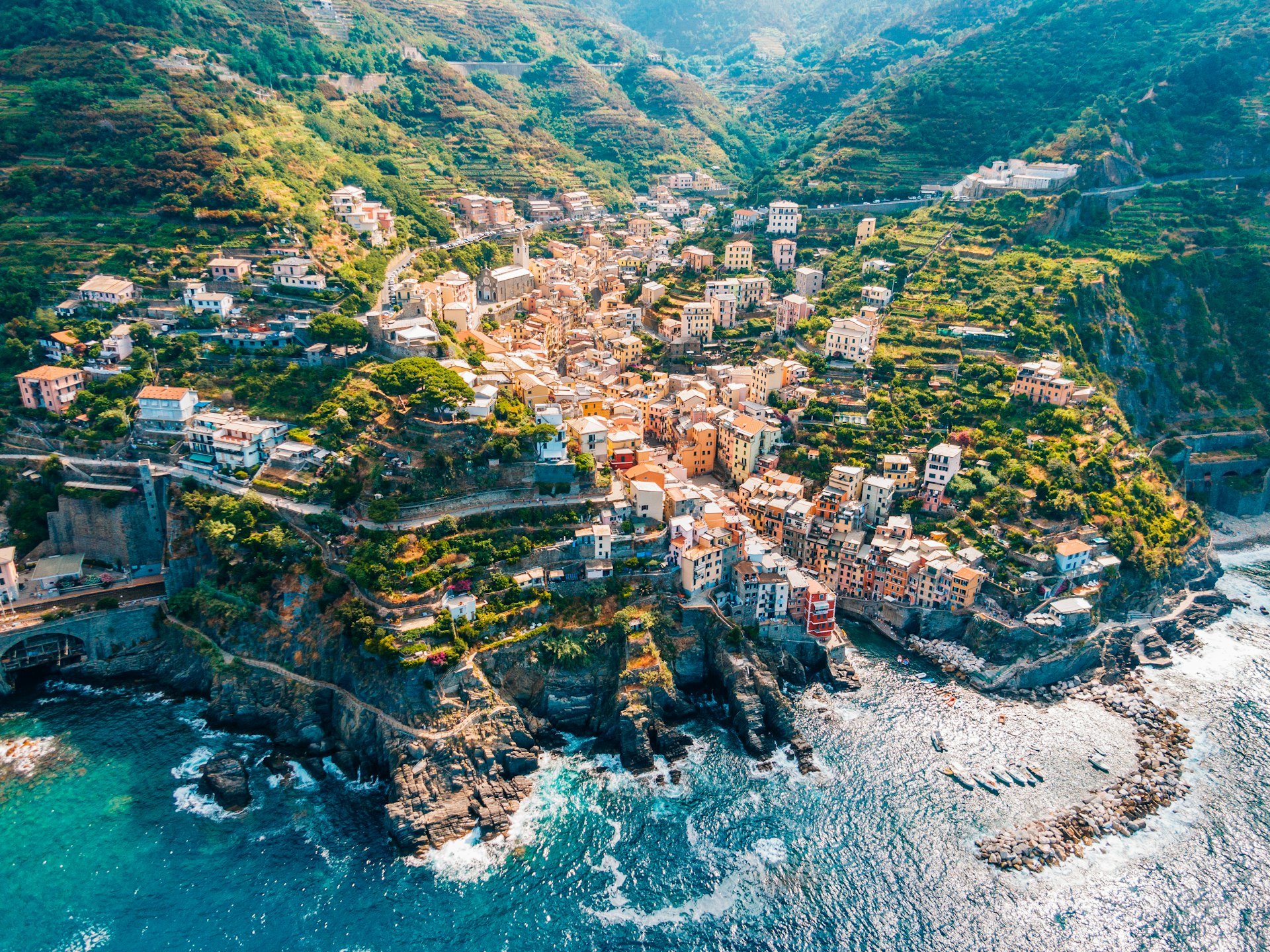 Town in mountains towering over tranquil sea in Cinque Terre. 