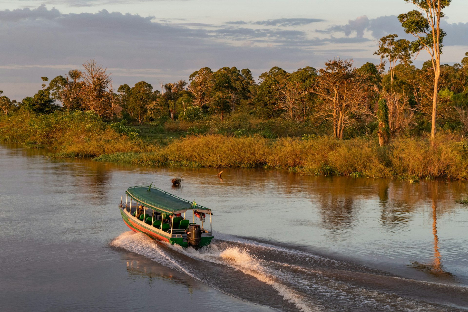 Passenger transport - speed boat at sunrise in the Amazon