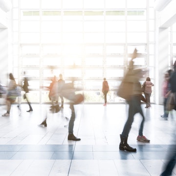 Long exposure of blurred people walking at a New York City airport.