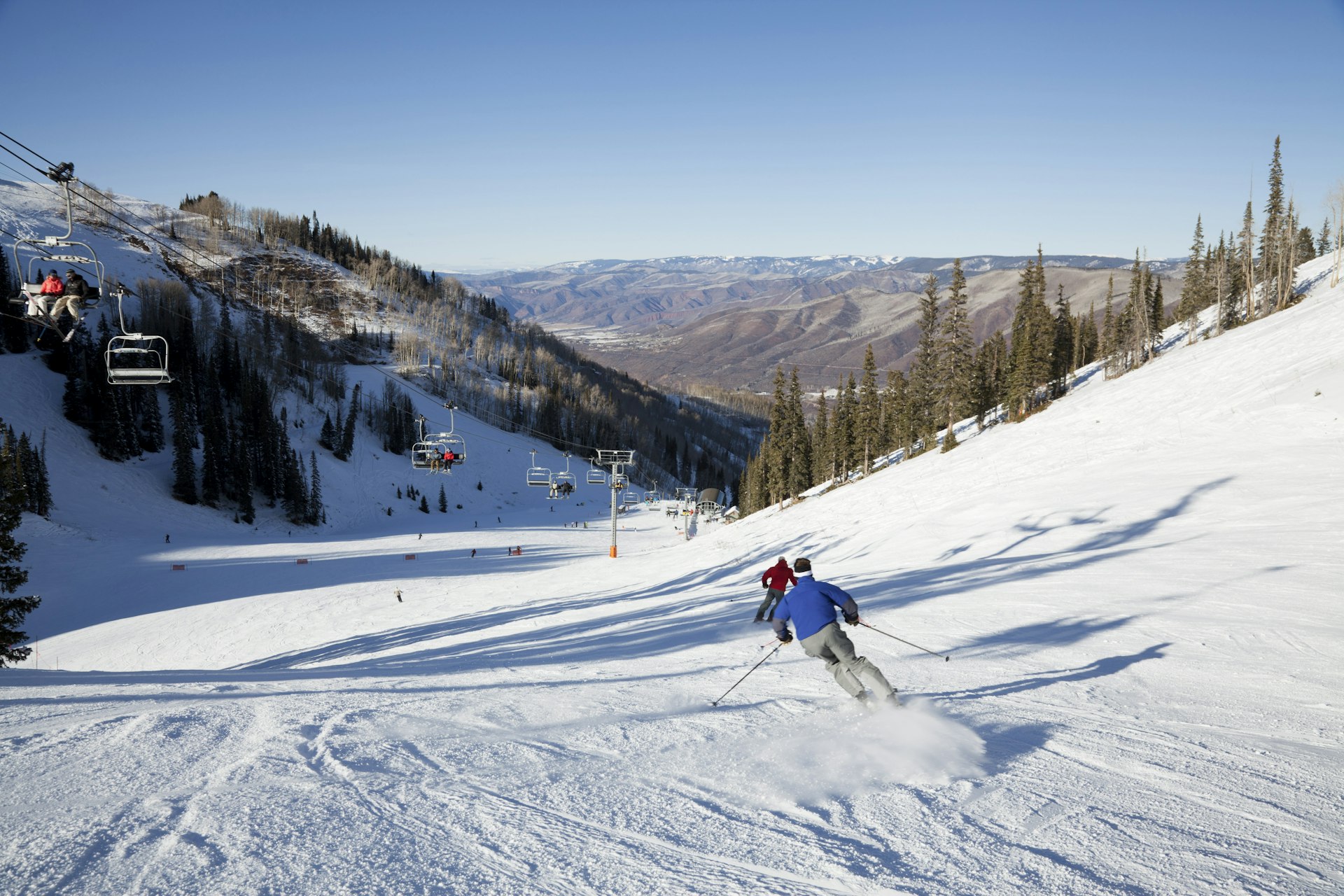 Skiers cruise down the hill in Aspen 
