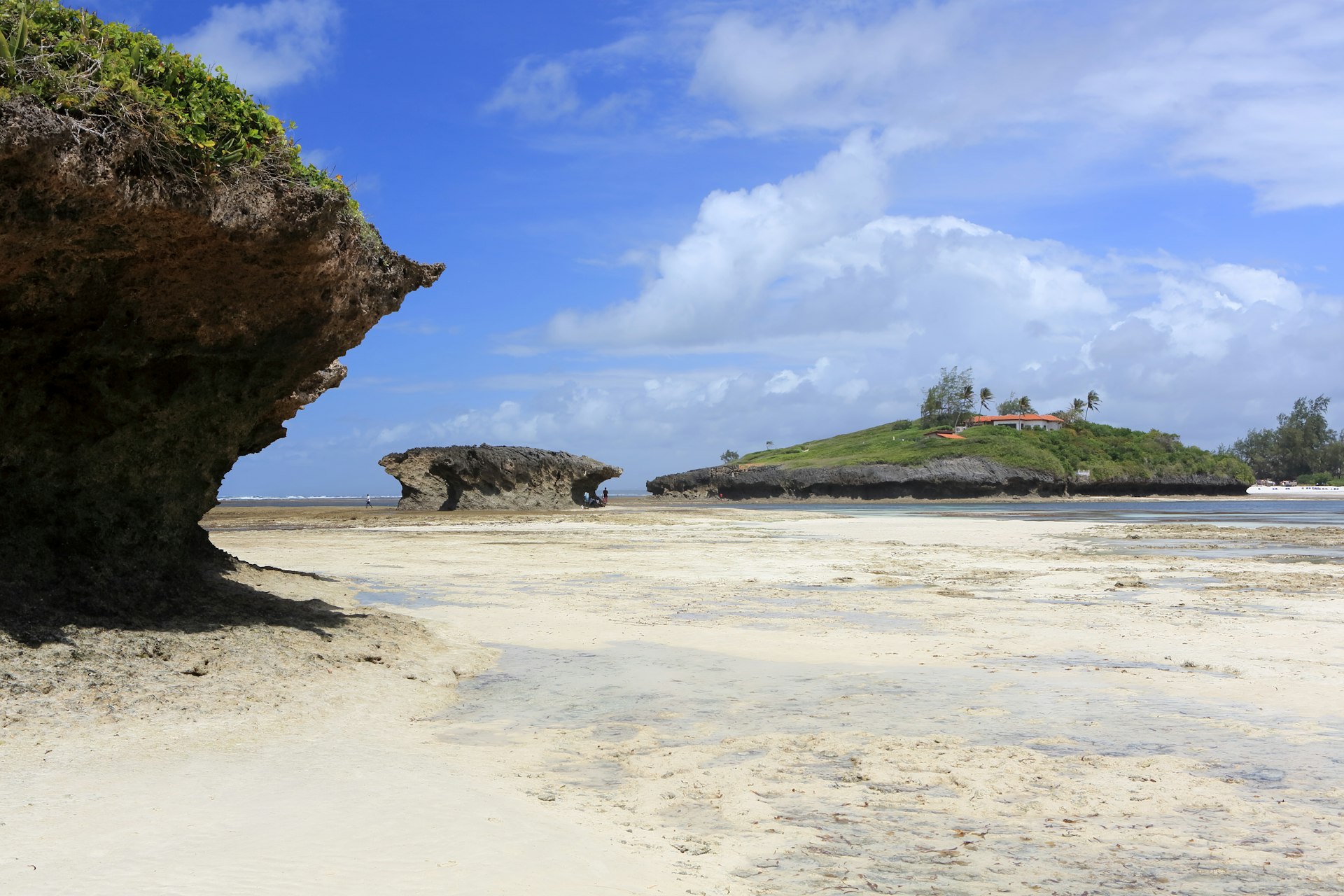 Rocks white-sand beach leads to light blue water at Watamu Marine National Park, Watamu.