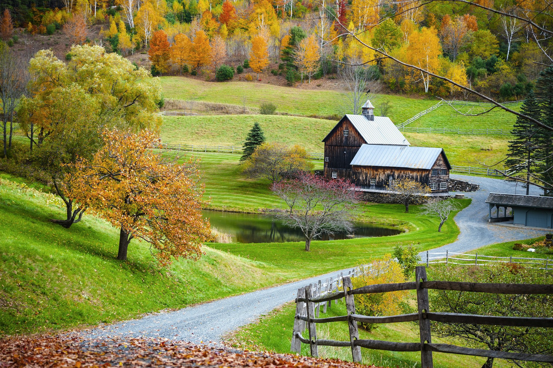 Old wooden barn surrounded by colorful trees, farm in autumn landscape