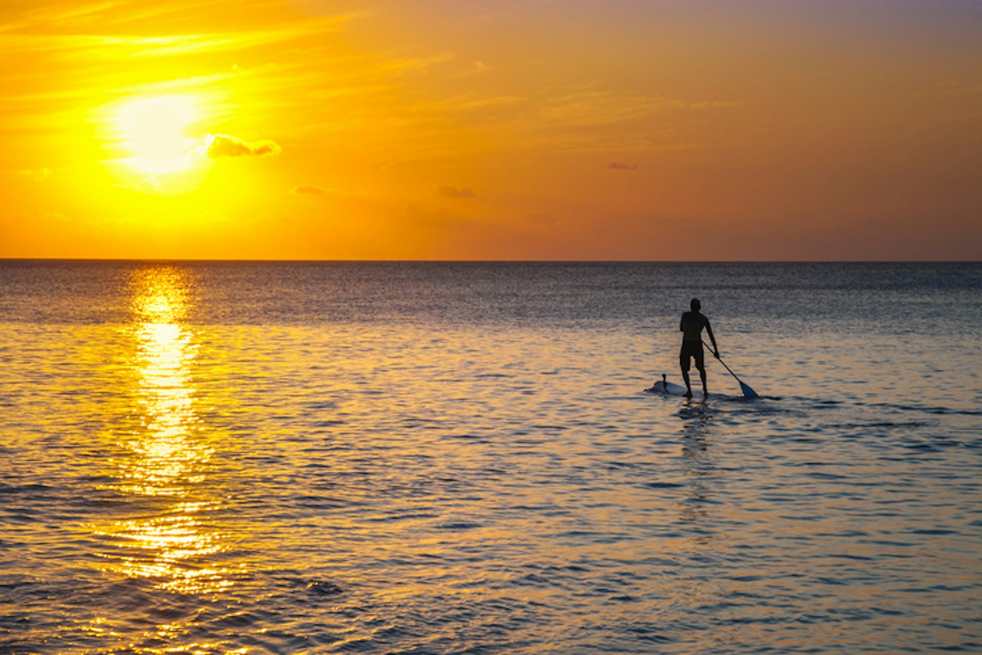 A standup paddleboarder at sunset, Conceicao Beach in Fernando de Noronha