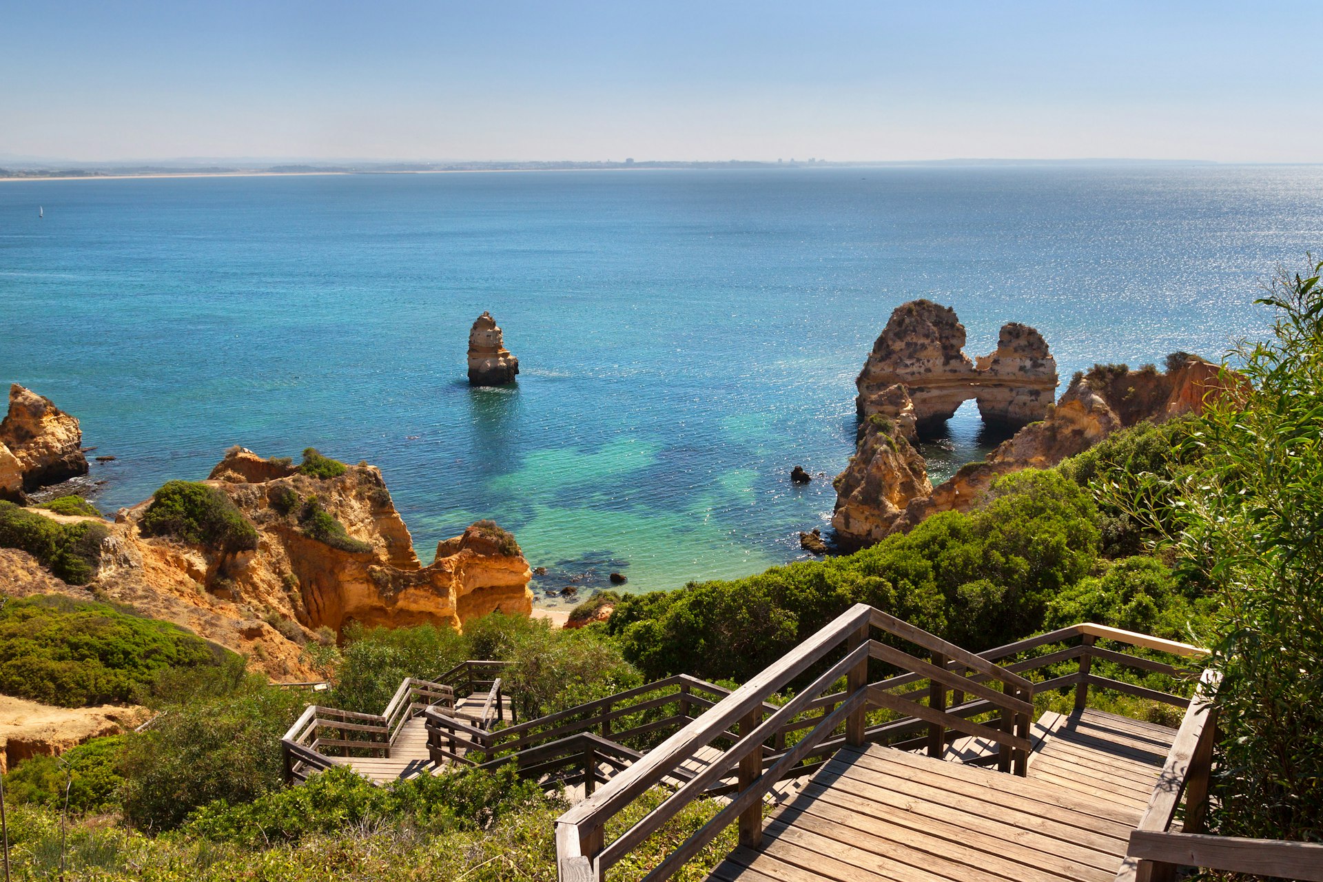Wooden footbridge to beautiful beach with cliffs in Algarve, Portugal
