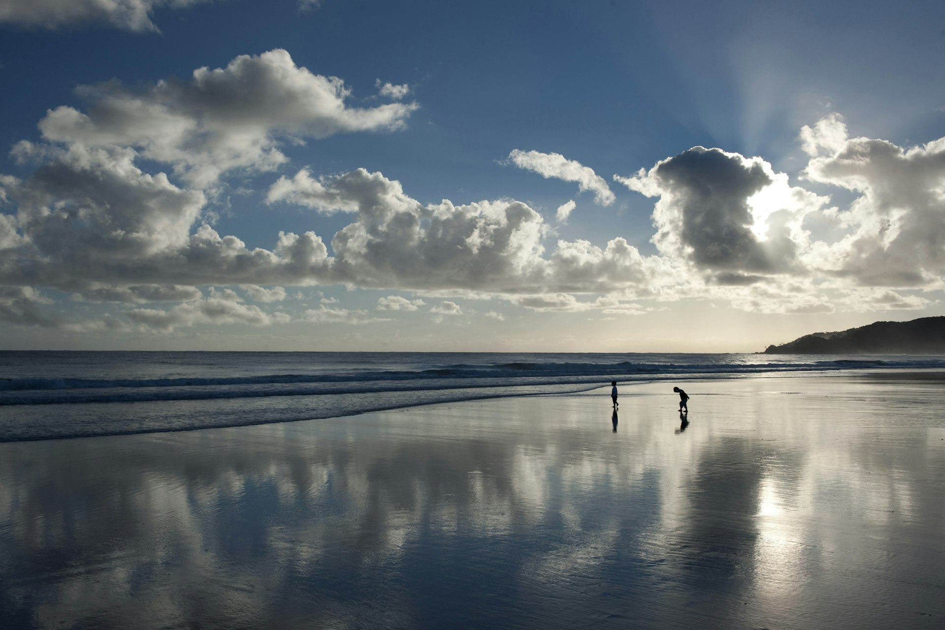 Children play on a beach in early morning in Byron Bay