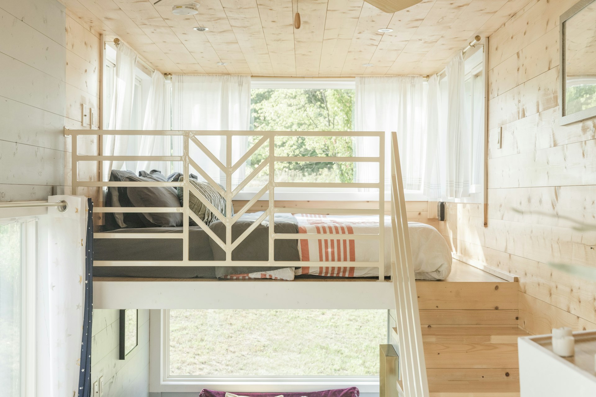 Lofted bedroom in open-plan tiny wooden home