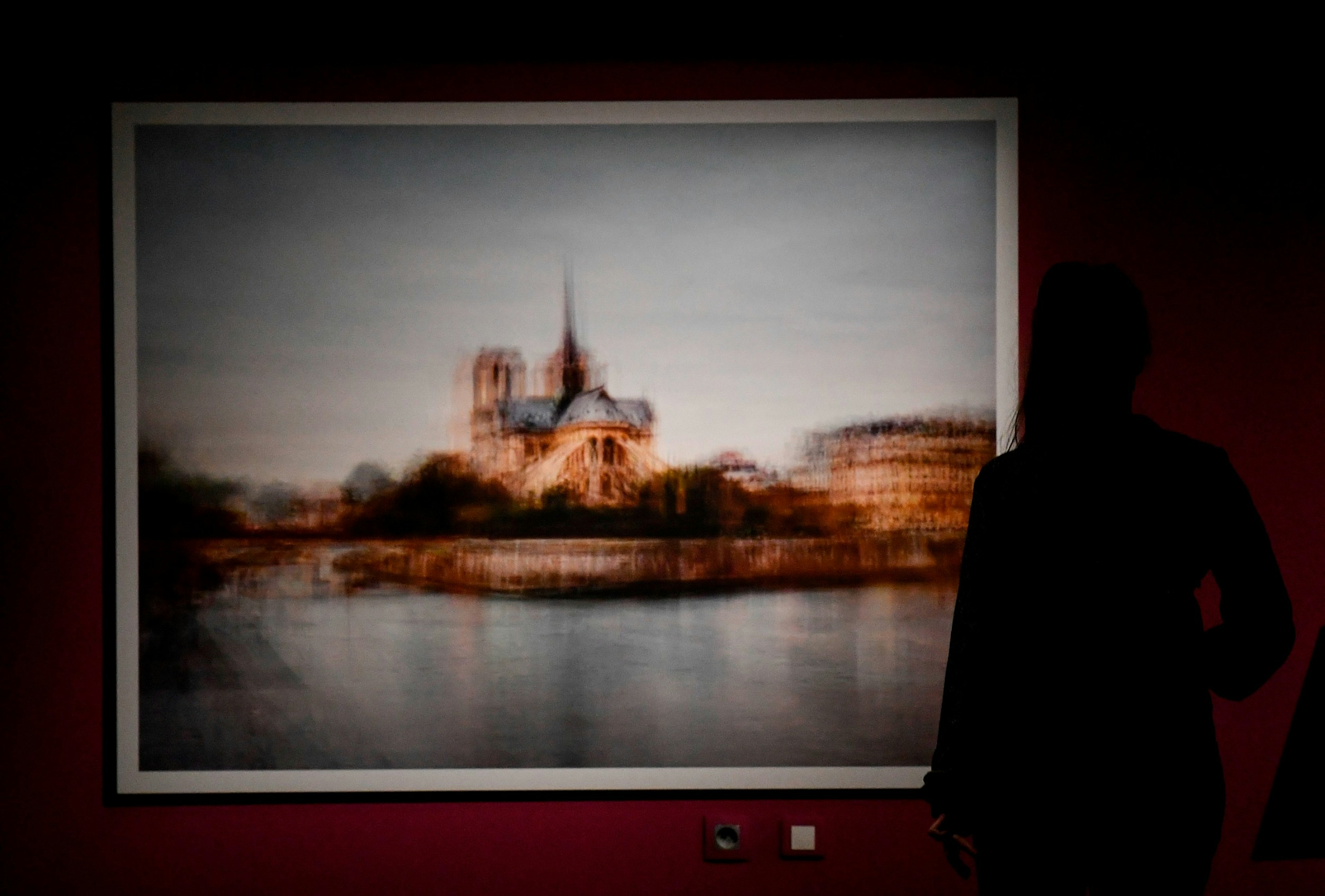 A person watches a picture by Corinne Vionnet during the press preview of the exhibition from Victor Hugo to Viollet-le-Duc in the external crypt of the Cathedral Notre-Dame de Paris