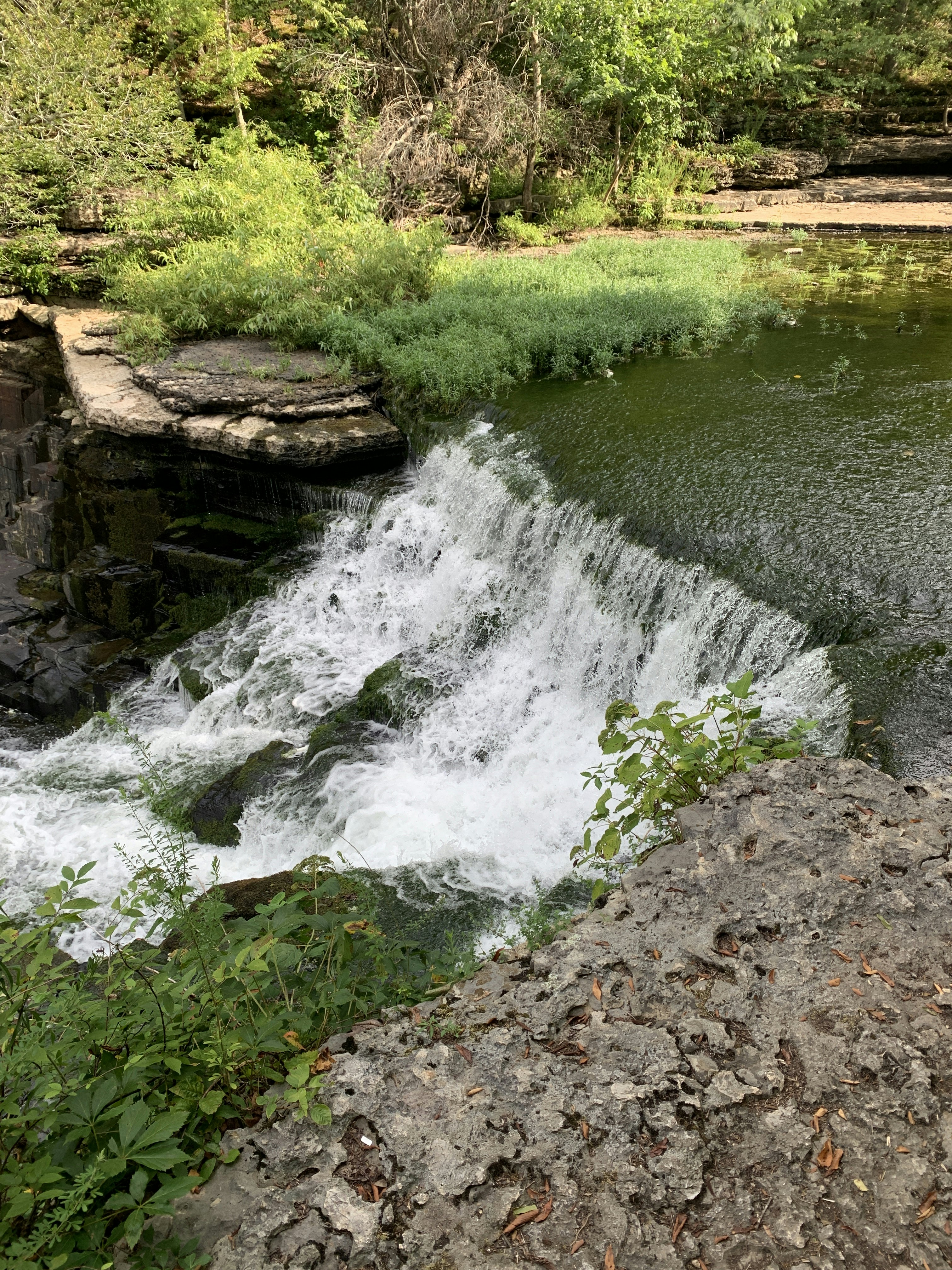 A small waterfall in in a green wooded area at Old Stone Fort State Archaeological Park in Manchester, Tennessee