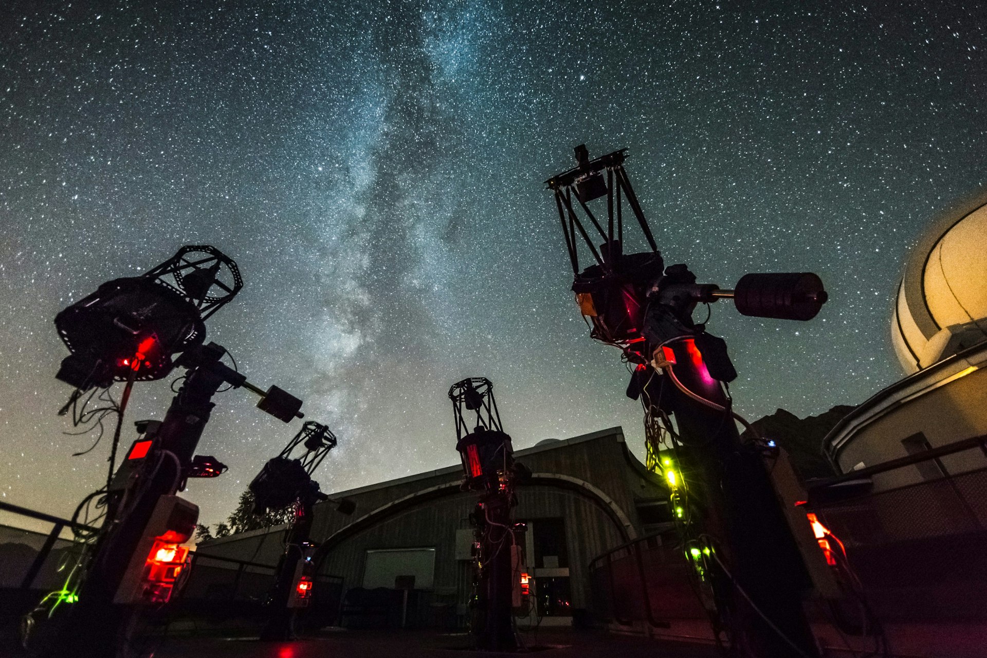 Telescopes in front of a star-filled sky