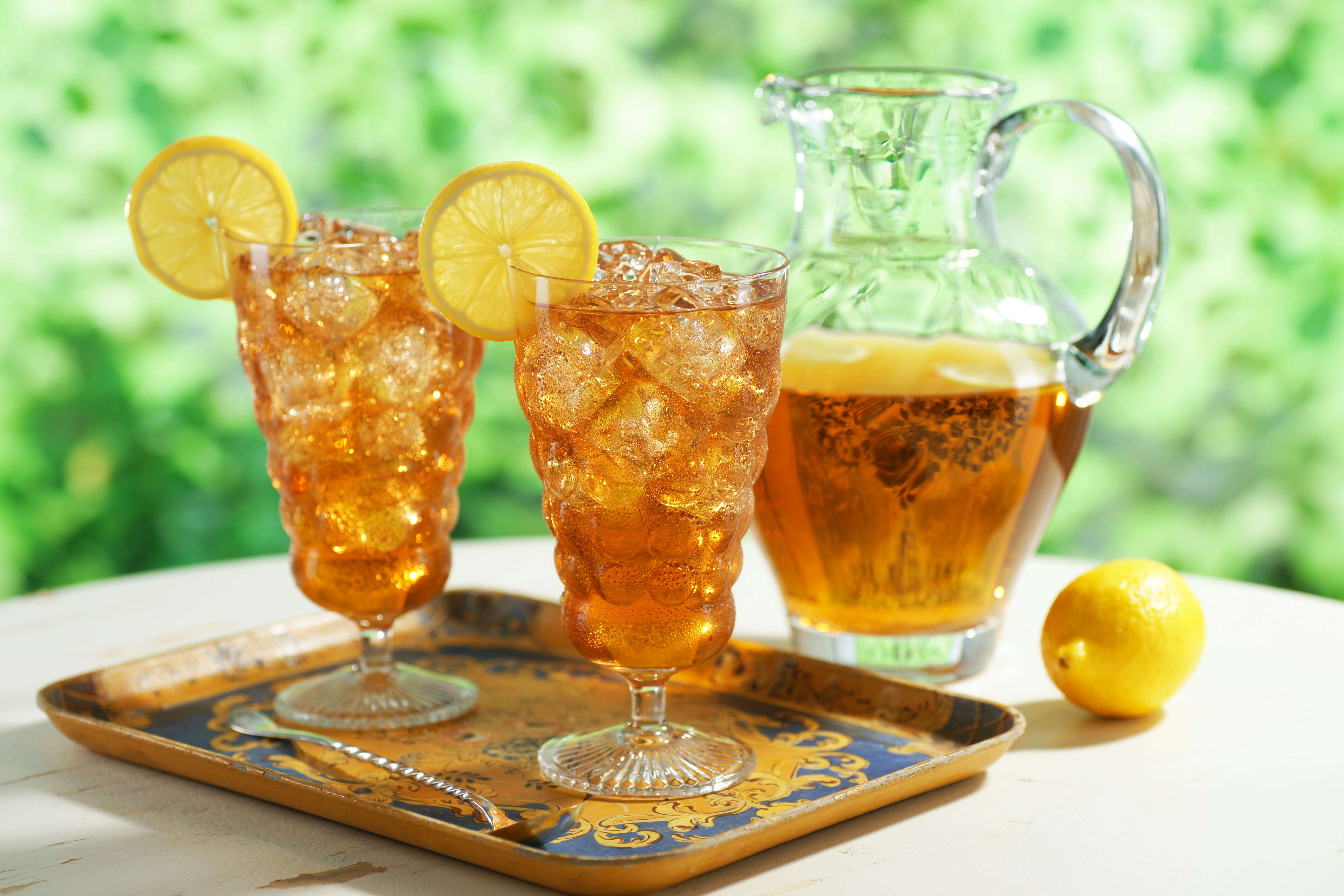 Two glasses of iced tea with pitcher