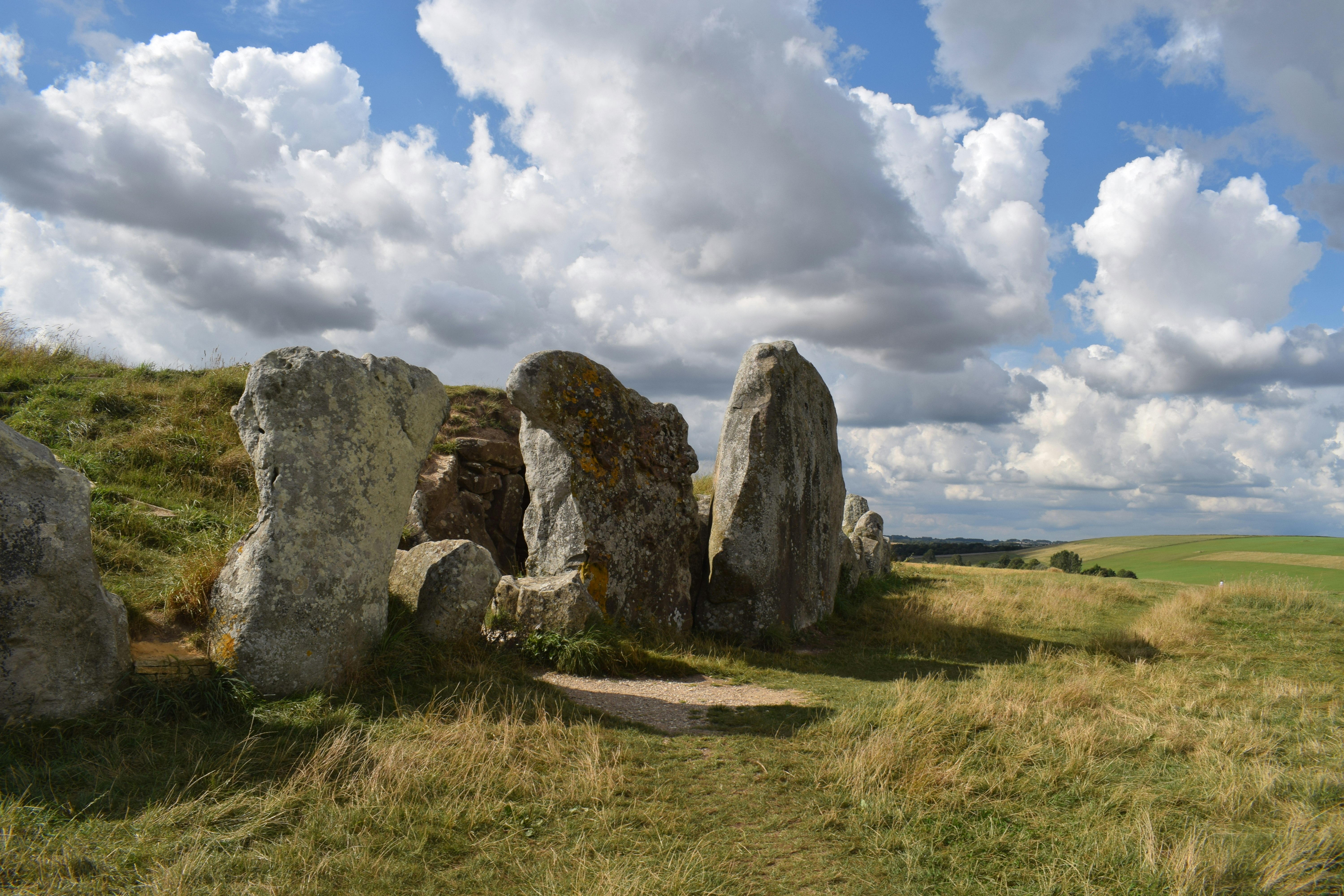 A pile of large stones standing on their ends surrounding a mound of earth