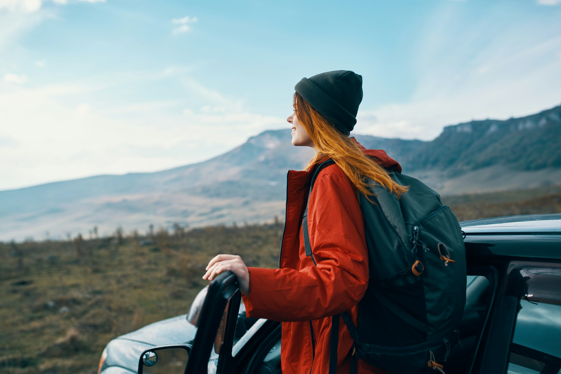 Woman tourist in the car looks at the mountains