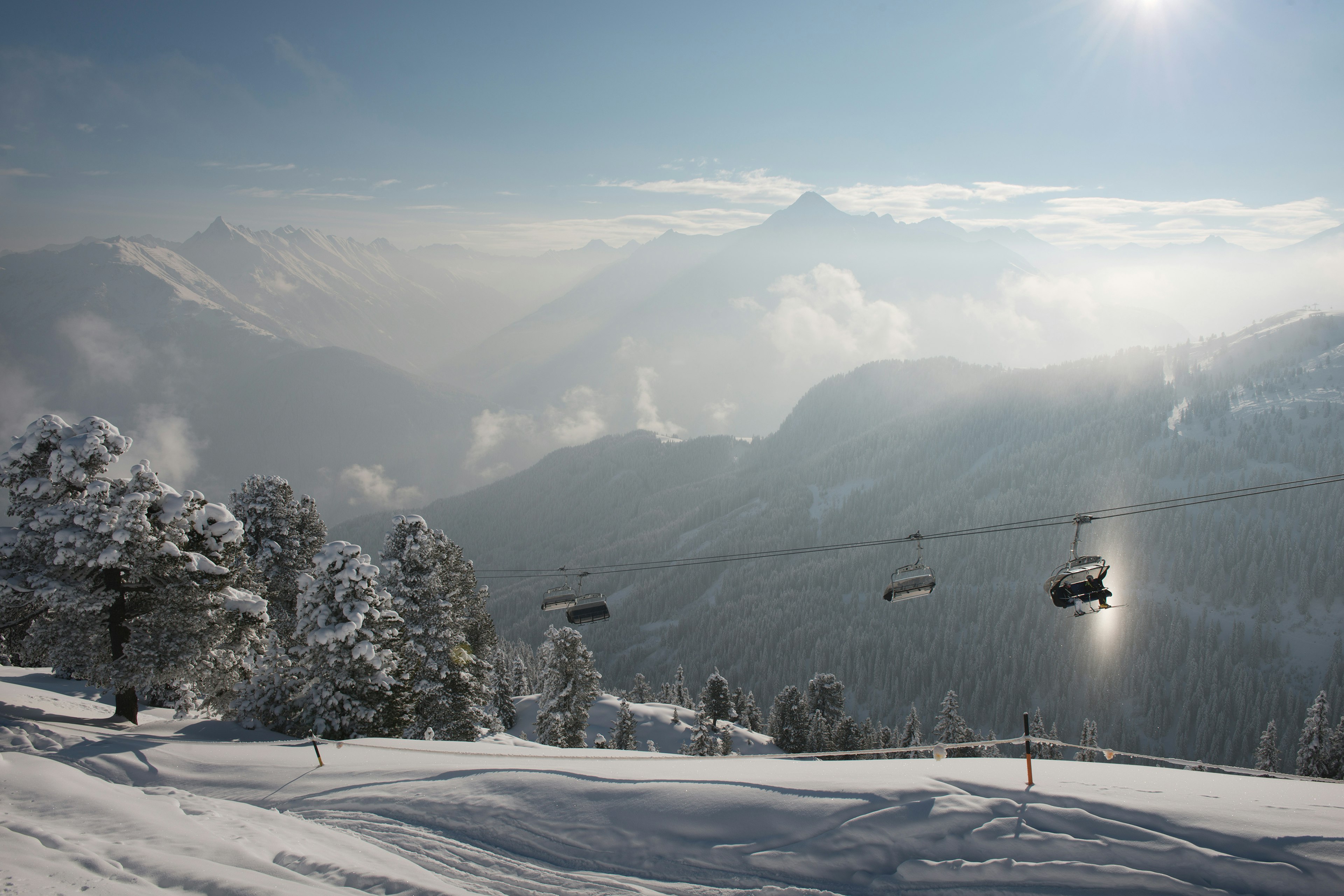 A very snowy ski slope with a silhouette of cable cars