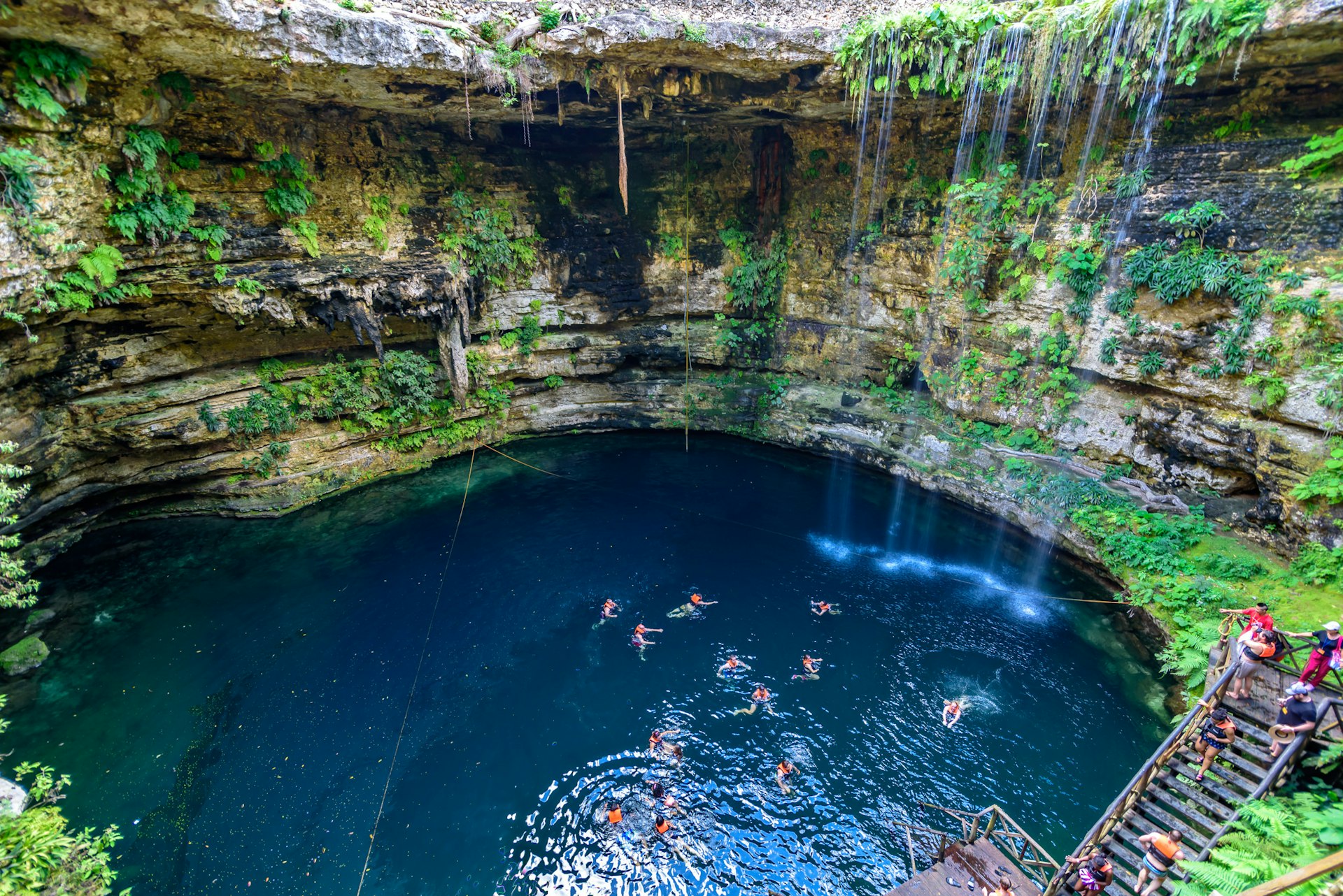 An overhead shot of people swimming in a cenote