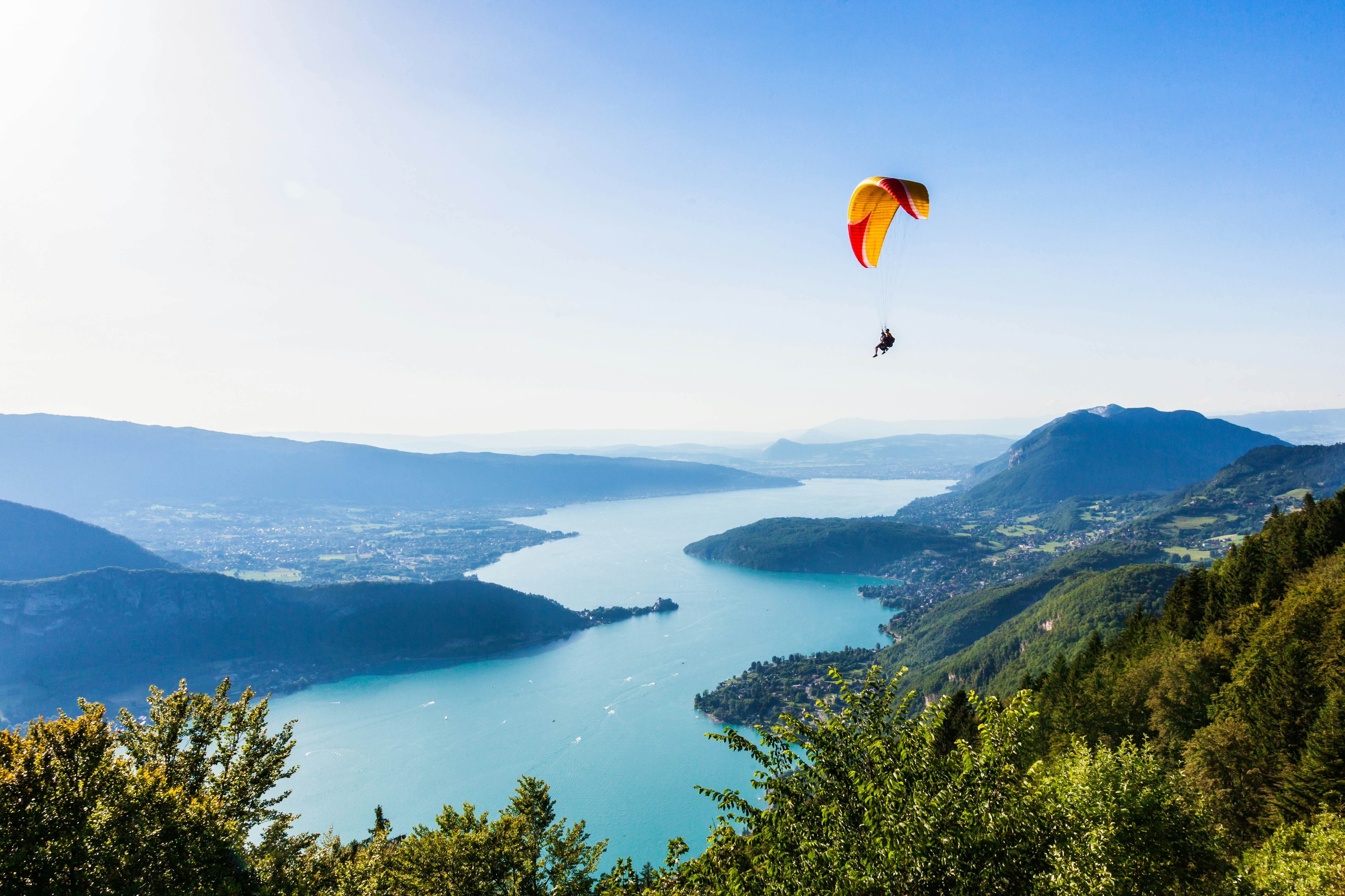 A parachute gliding above an alpine lake