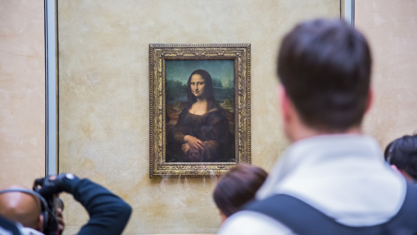 PARIS - AUGUST 4: Visitors take photo of Leonardo DaVinci's "Mona Lisa" at the Louvre Museum, August 4, 2012 in Paris, France. The painting is one of the world's most famous.