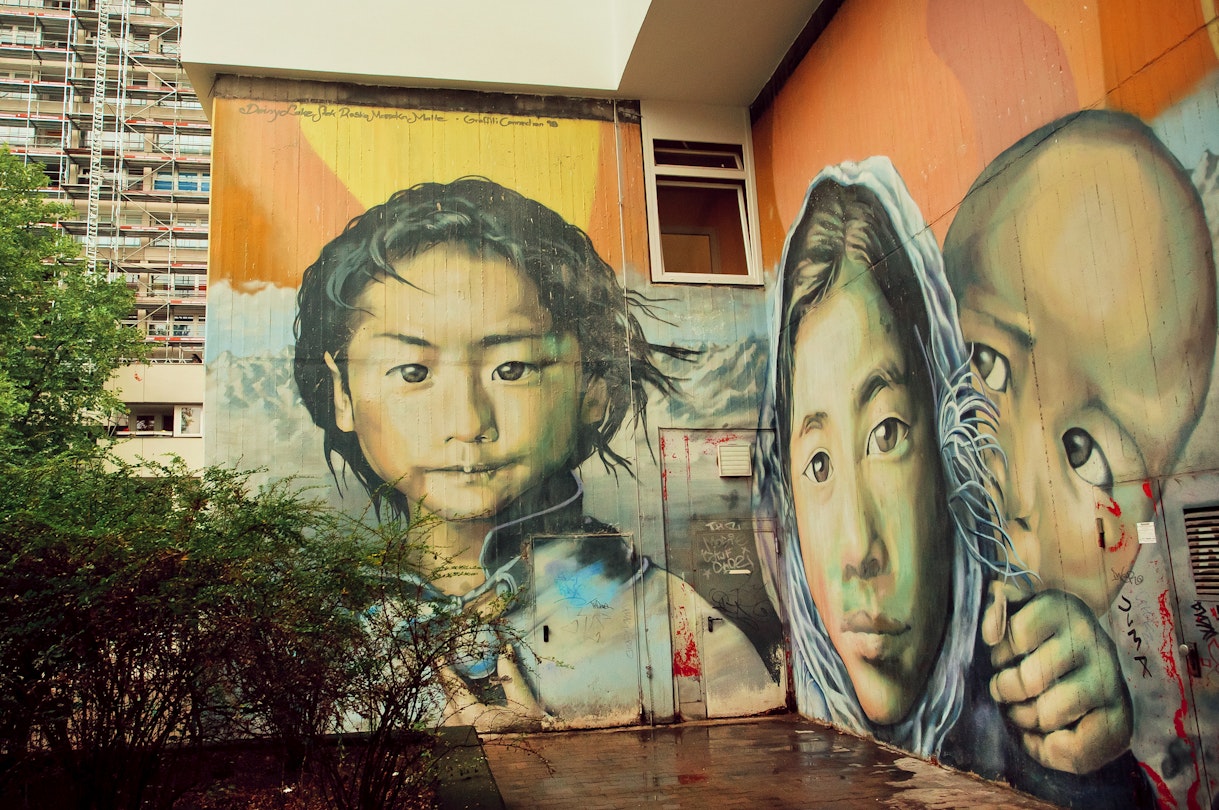 BERLIN, GERMANY - SEPT 2, 2015: Graffiti with poor girl face, child from a refugees family on Septemper 2, 2015. Urban area of Berlin comprised 4 million people, 7th most populous in EU.