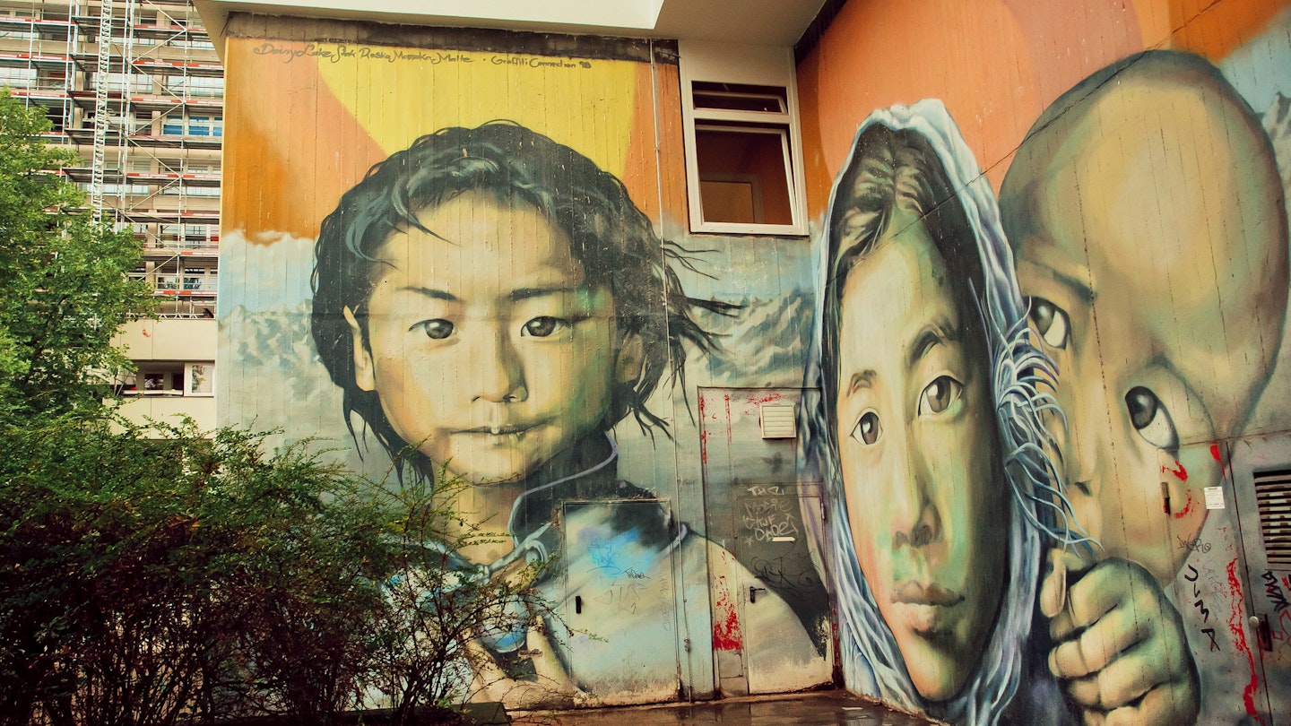 BERLIN, GERMANY - SEPT 2, 2015: Graffiti with poor girl face, child from a refugees family on Septemper 2, 2015. Urban area of Berlin comprised 4 million people, 7th most populous in EU.