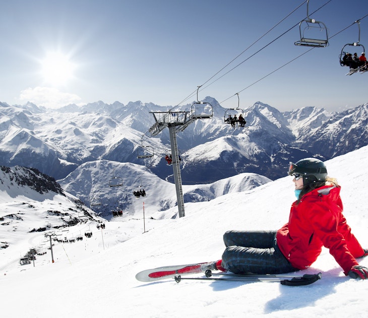 Girl skier lying on snow with ski, French Alps High mountain
