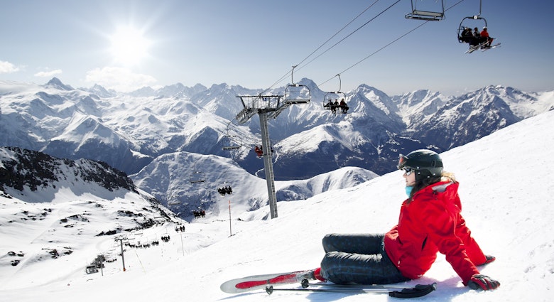 Girl skier lying on snow with ski, French Alps High mountain