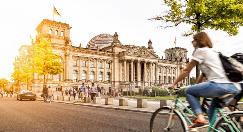 Urban city life with famous Reichstag building in the background in beautiful golden evening light at sunset in summer with retro vintage Instagram style pastel toned filter effect, Berlin, Germany