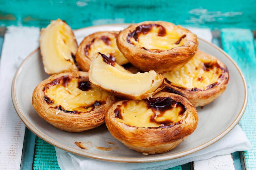 A plate of pastel de nata (custard tarts) on a blue table in Portugal