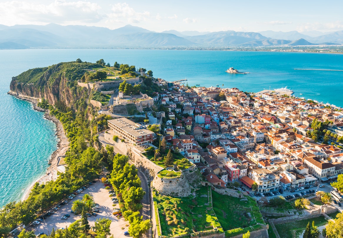Aerial of Nafplio city with the port, Bourtzi fortress and blue Mediterranean sea.
