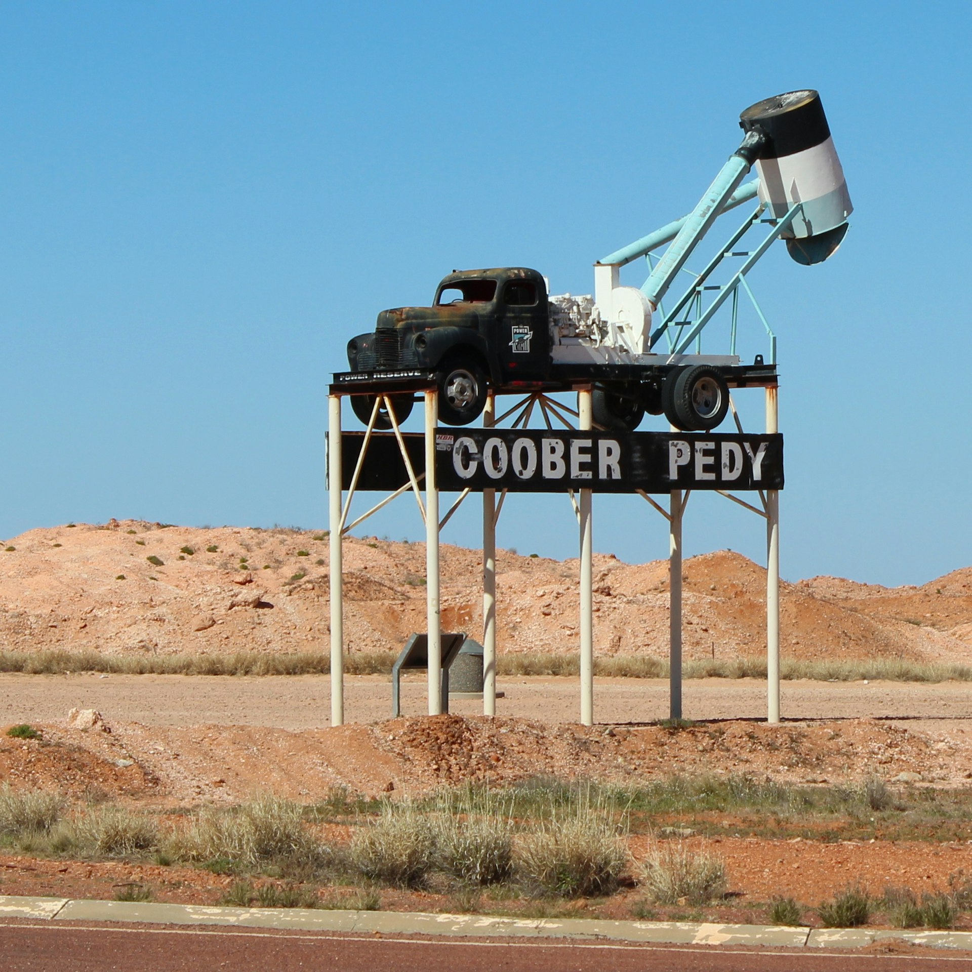 An old mining truck above the Coober Pedy town sign