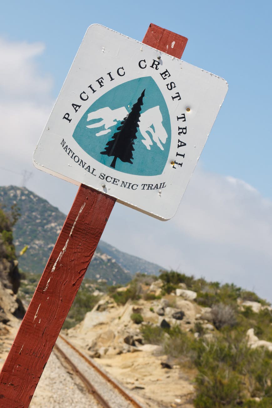 En teckenläsning "Pacific Crest Trail" mot en blå bakgrund