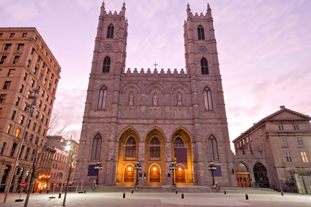 Basilica of Notre-Dame in Montreal The exterior of a Gothic twin-towered cathedral building on an empty city square