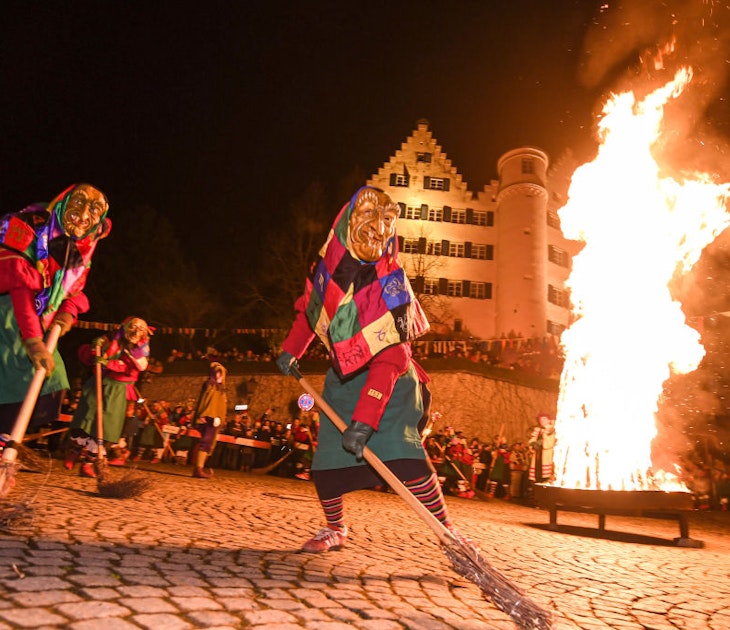 19 February 2020, Baden-Wuerttemberg, Aulendorf: Corner witches of the fool guild Aulendorf dance around a fire in the early evening below the castle. The mystical mask conjuration at the Hexeneck is part of the foolish tradition. That night the fools awoke from their sleep. Until Ash Wednesday the fool's freedom is now valid in the tranquil Upper Swabian town of Aulendorf. Photo: Felix Kästle/dpa (Photo by Felix Kästle/picture alliance via Getty Images)
