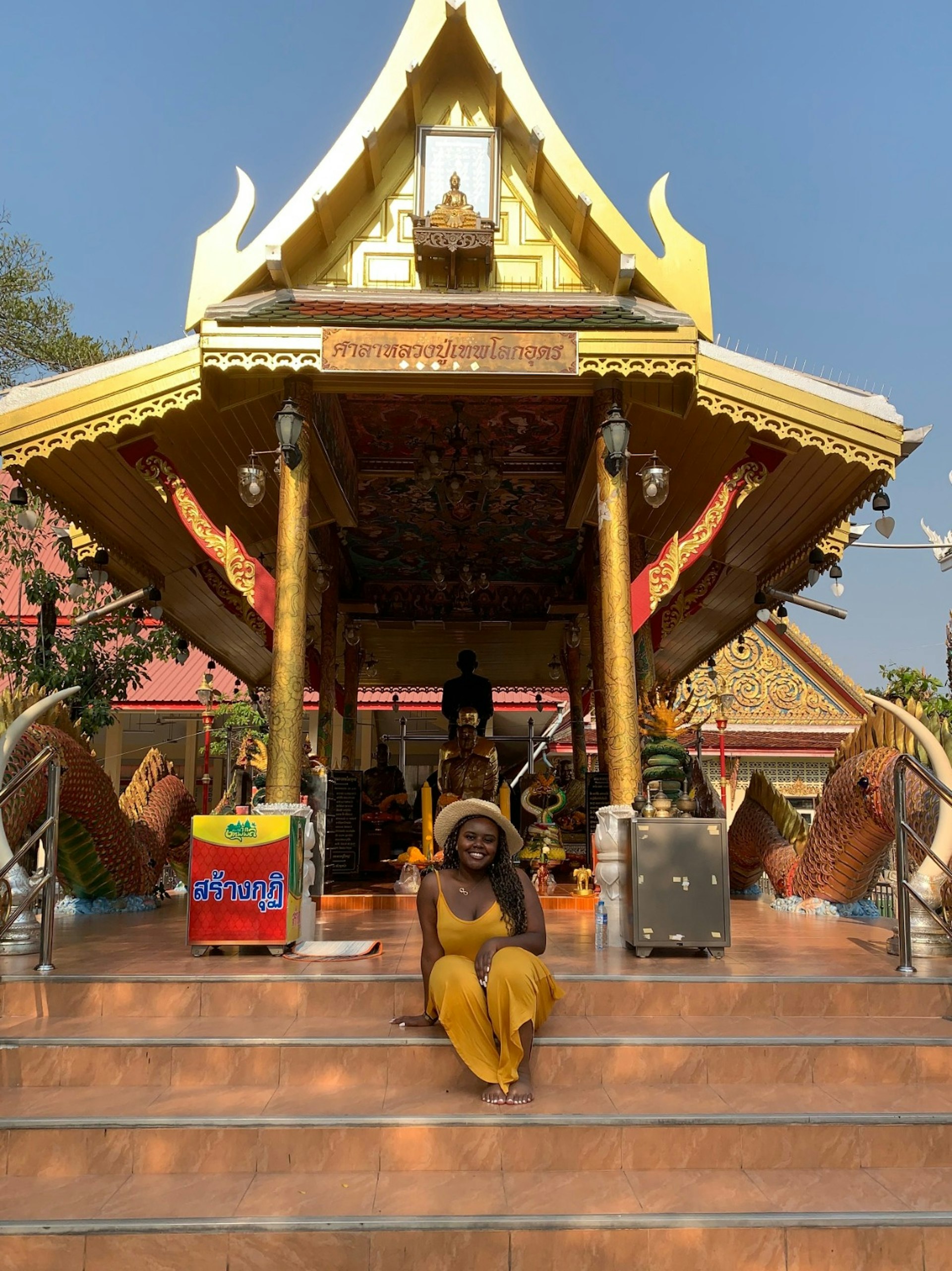A woman sits on the steps of an Asian temple