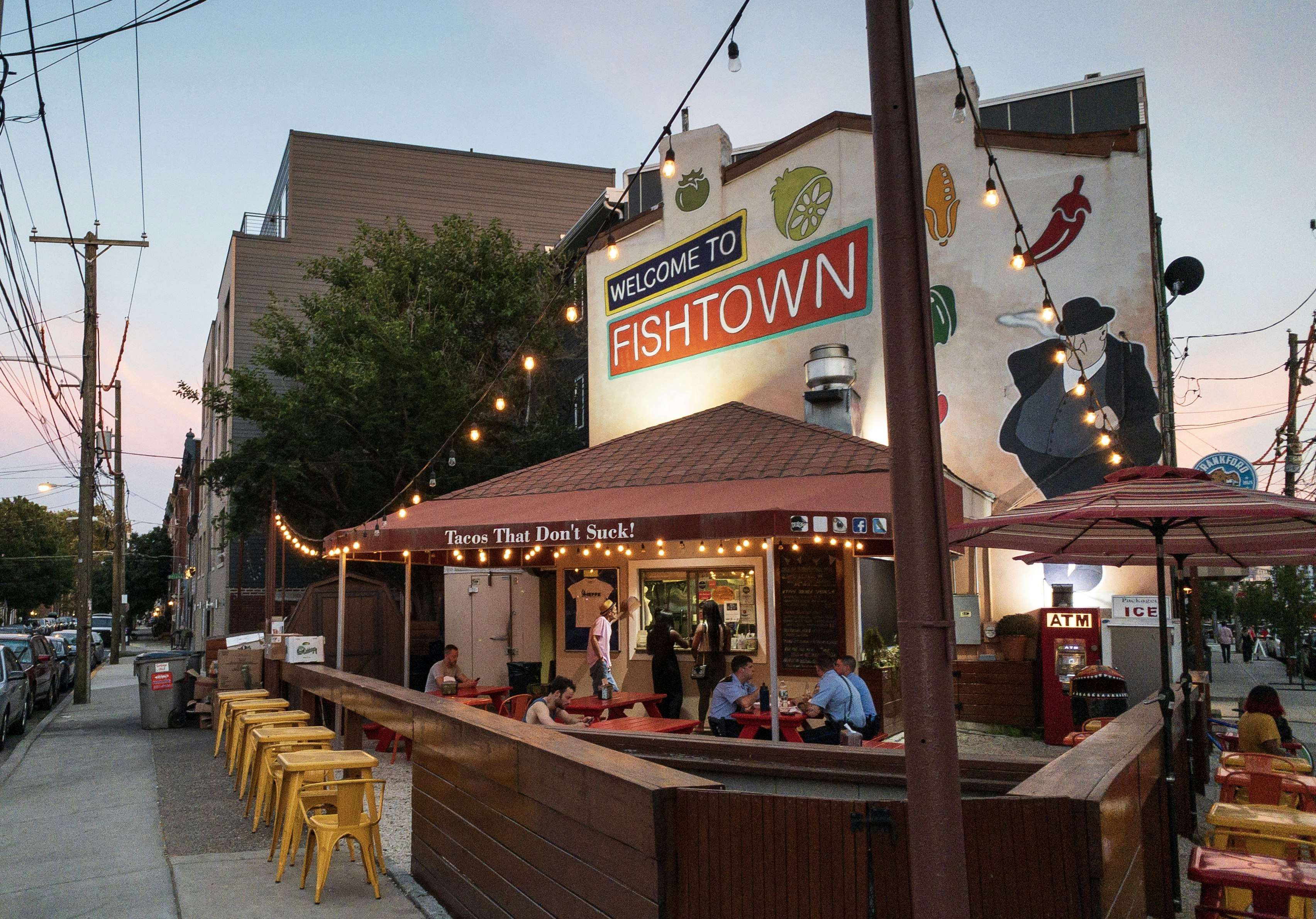 A few people sit at tables at a restaurant with outdoor dining in  the Fishtown area of North Philadelphia