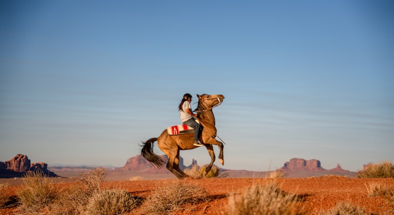 A Dine boy rides his horse in the Navajo Nation in the southwestern United States