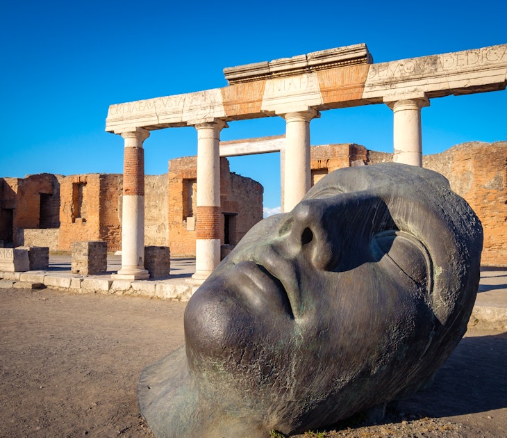 Scenic view of ruins and bronze statue in ancient Pompeii city, Italy
